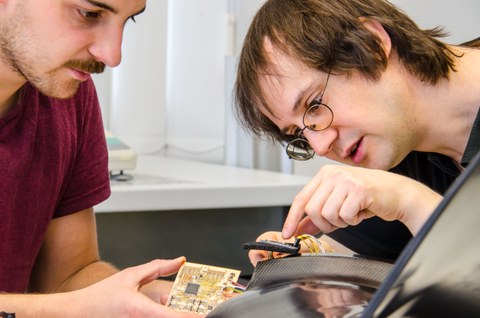 Zwei Wissenschaftler des Instituts für Leichtbau und Kunststofftechnik arbeiten den der funktionsintegierten Elektronik eines Fanbades.