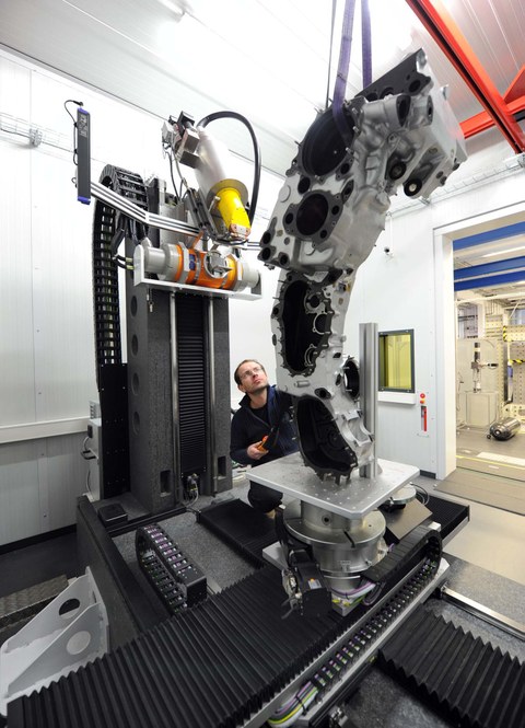 Ein Wissenschaftler des Instituts für Leichtbau und Kunststoftechnik spannt ein Bauteil im Computertomographen ein.
