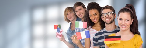 Foto von Studierenden unterschiedlicher Nationalitäten, die hintereinander in einer Reihe stehen und jeweils eine andere Flagge in der Hand halten.