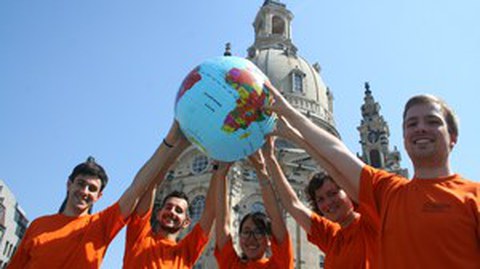 Tutorienprogramm des IO-TUD. Menschen halten Erdkugel vor der Frauenkirche