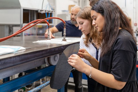 Two students examine a material component.