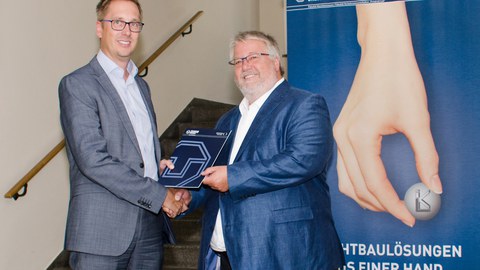 Prof. Maik Gude übergibt im Namen des Runden Tisches „Life Cycle Assessment (LCA)“ das Positionspapier an Dr. Herbert Zeisel, BMBF