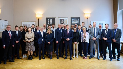 Group photo: Group of people standing frontally, smiling at the camera.