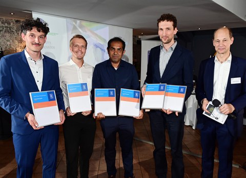 Group photo of five people. They are holding certificates and smiling at the camera.