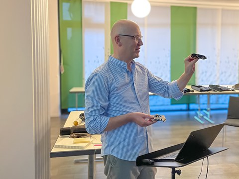 Prof. Modler zeigt ein Bauteil aus faserverstärktem Verbundwerkstoff in seinem Vortrag.