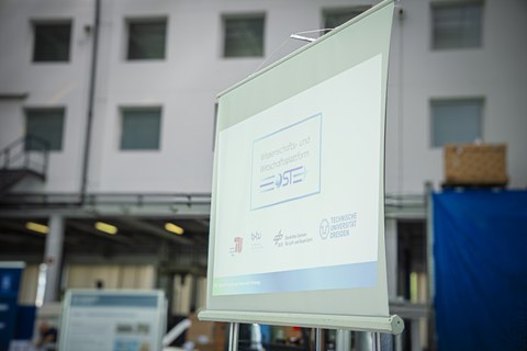 A screen displaying the words “Science and Business Platform OST.” Below it are the logos of TU Berlin, btu, DLR, and TU Dresden.