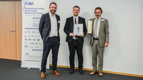 Presentation of the award certificate to Dipl.-Ing. Levin Schilling (in the middle) by WAK member Prof. Dr.-Ing. Volker Altstädt (right) and the representative of the donor company Oechsler Dipl.-Ing. Matthias Weißkopf (left)