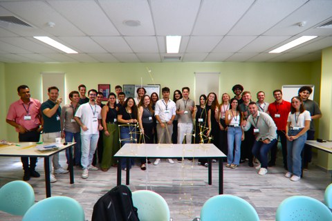 Gruppenfoto von allen Student:innen. Davor stehen die Spaghettitürme auf einem Tisch.