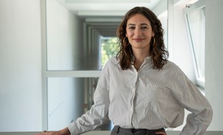 Eine Frau schaut in die Kamera und lächelt.