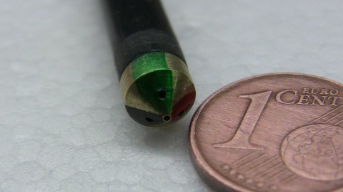 Head of a four-hole cone-shaped probe compared to a one-cent coin