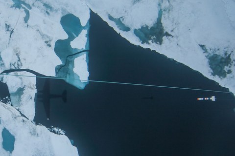 Schatten von Trägerflugzeug und Schleppkörper über dem Eismeer