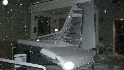 schneebedecktes Heck einer Do228 vor dem Institutsgebäude