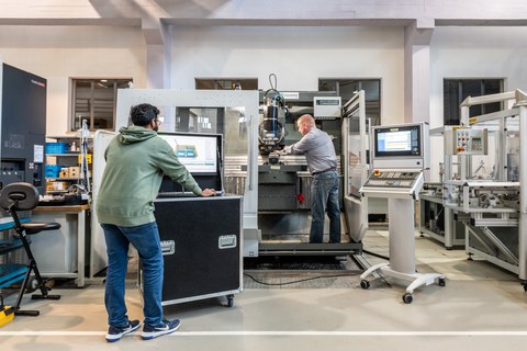 zwei Mitarbeiter bedienen eine Maschine