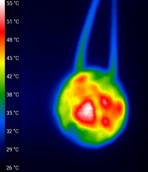 Das mit einer Wärmebildkamera aufgezeichnete Bild zeigt den ersten Prototypen mit zwei angeschlossenen Kabeln. Auf der Sensorfläche sind starke sich unterscheidende Temperaturbereiche zu erkennen.