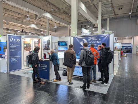 Menschengruppe am AST Messestand