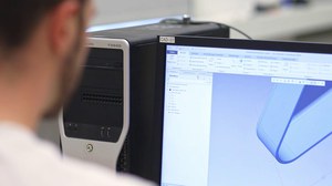 Student sitz an PC mit Blick auf Monitor auf dem ein CAD-Modell zu sehen ist