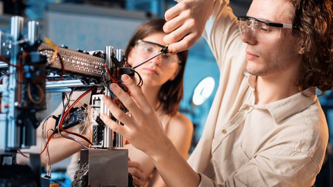 2 Studenten montieren einen kleinen Roboter