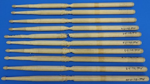 Im Bild sind verschiedene Drumsticks aus der Holzart Hickory nach einem Belastungstest zur Abnutzung dargestellt.