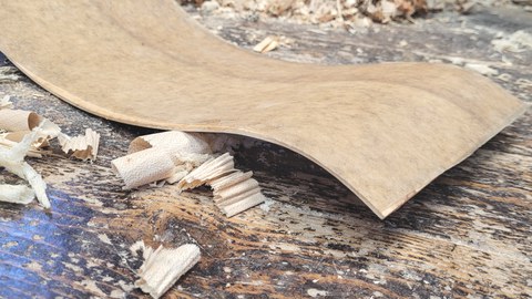 Im Bild liegt eine Kontrabsszarge auf einer Werkbank. Die Zarge ist mit einem Naturfaser-Textil verstärkt.