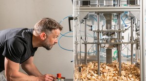 Im Bild ist zu sehen, wie eine Person eine Laborvorrichtung zum Stanzen von Holzpflaster bedient.