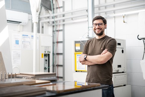 Das Bild zeigt einen braunhaarigen Mann (A. Hoffmeister) vor einer Werkbank