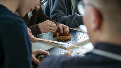 Kinder haben Furnierstreifen in der Hand und biegen diese