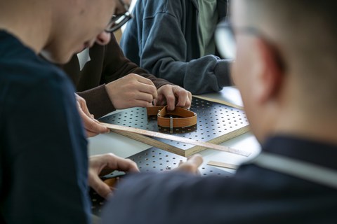 Kinder haben Furnierstreifen in der Hand und biegen diese
