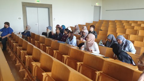 Mehrere malayische Studierende hören einer Vorlesung zu und machen Notizen.