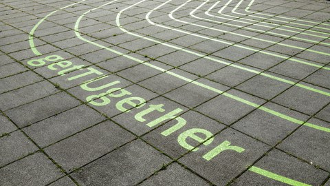 grüner Schriftzug get TUgehter auf Boden aus Betonplatten