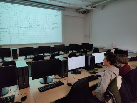 Zwei jungen sitzen am Coputer und betrachten Graphen.