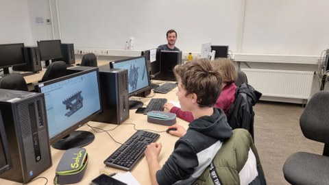 Zwei jungen am PC mit Baugruppe auf Bildschirm.