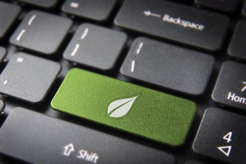 Foto einer Computertastatur mit einer grünen Taste mit einem grünen Blatt darauf