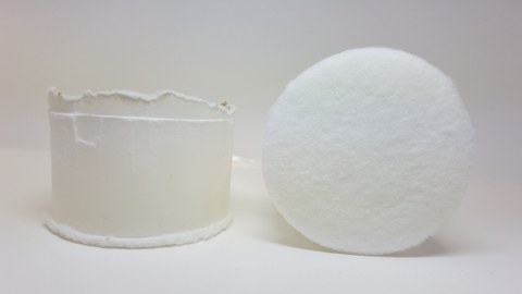 weißer Zylinder mit klarem Absatz am oberen Ende und Verdickung am unteren Ende.