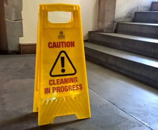 Gelber Aufsteller mit der Aufschrift "Caution - Cleaning in Progress"