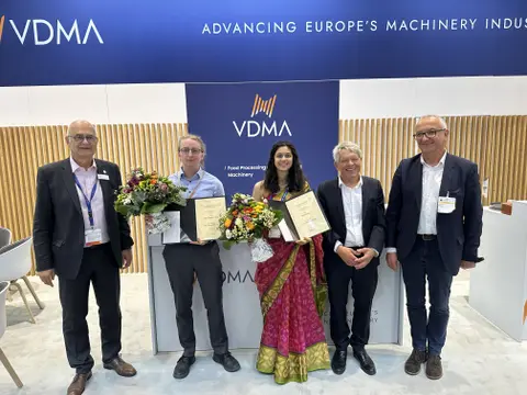 Foto von 5 Personen. Zwei Personen halten einen Blumenstrauß und eine Urkunde. Alle Lächeln in die Kamera.