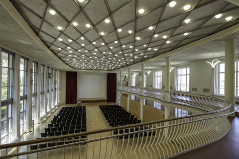 Foto eines Festsaals der TU Dresden, dem Dülfersaal mit Reihenbestuhlung und einer Bühne von oben.