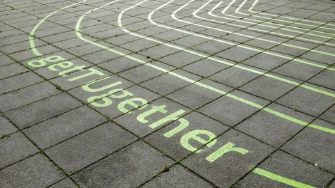 grüner Schriftzug get TUgehter auf Boden aus Betonplatten