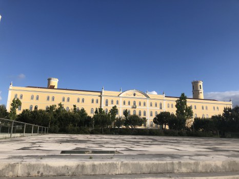 Gelbes Universitätsgebäude vor blauem Himmel.