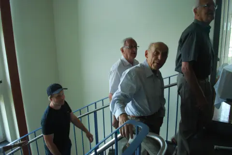Drei Männer gehenh eine Treppe hinauf.