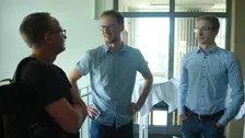 Drei Männer unterhalten sich.