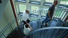 Drei Personen gehen eine Treppe hinauf.