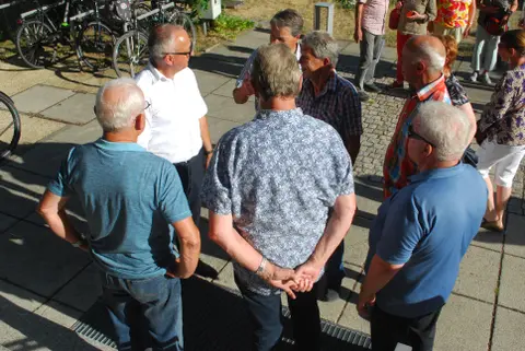 Gesprächsrunde mit 5 älteren Personen im Freien.