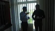 Zwei Männer mit Kaffeetasse im Gespräch.