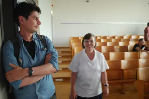 Eine Frau und ein Mann gehen durch den Hörsaal.
