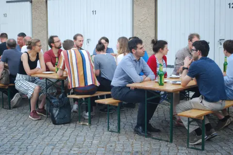 Foto von Menschen auf Bierbänken.