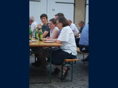Foto von Menschen auf Bierbänken.