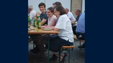 Foto von Menschen auf Bierbänken.