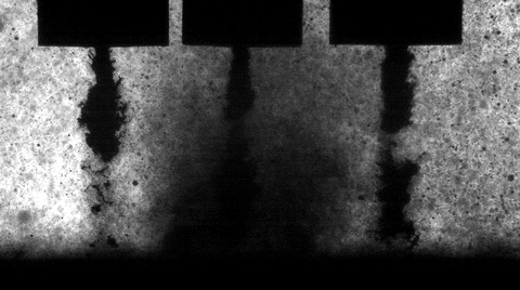 Anordnung von drei kavitierenden Prallstrahlen in Reihe. Aufgrund der beeinträchtigten abfließenden Strömung des mittleren Strahls ist dort eine höhere Blasendichte erkennbar.