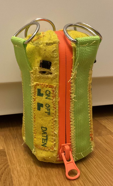 Fertige CanSat-Hülle aus Stoff mit Halterung für Fallschirm und Aussparungen für Kameras, über den Reißverschluss ist die Filzrolle mit den elektronischen Bauteilen leicht zugänglich. 