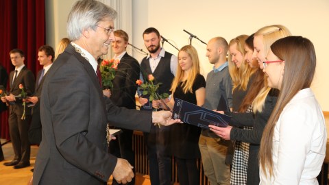 Das Foto zeigt den Rektor der TU Dresden, Professor Hans Müller-Steinhagen, der einer jungen Frau gerade eine Urkunde überreicht.